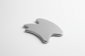 Stainless steel IASTM muscle scraping tool on white surface